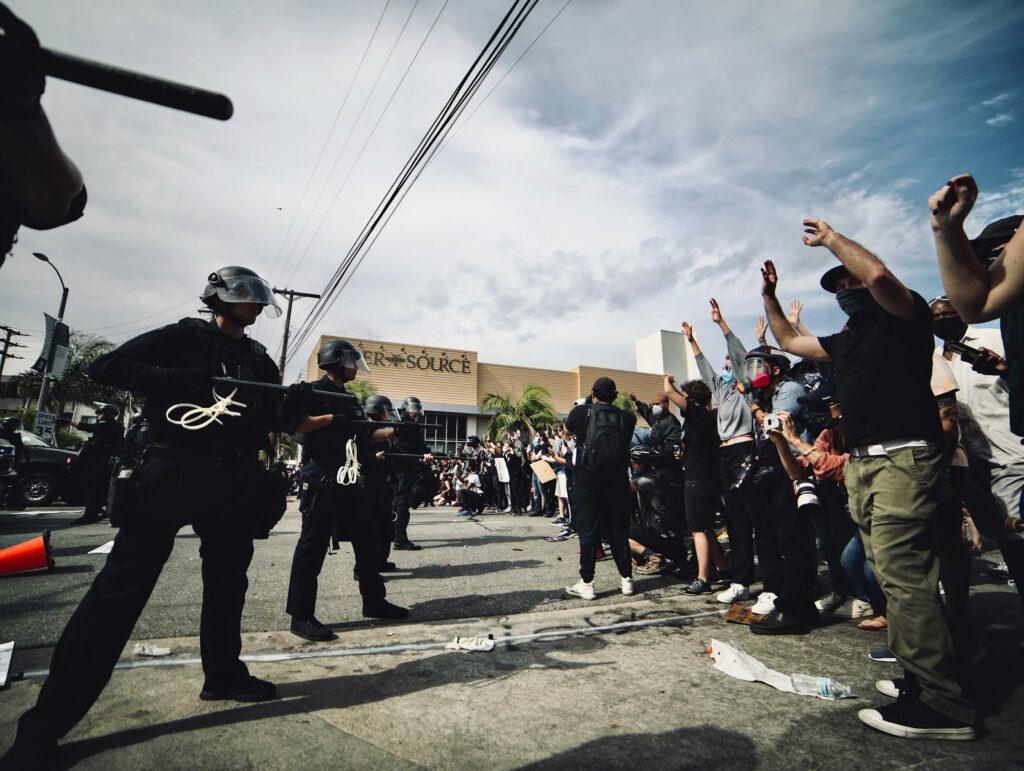 Protesters in L.A. protesting ICE raids, with Police in riot gear pushing back the protesters