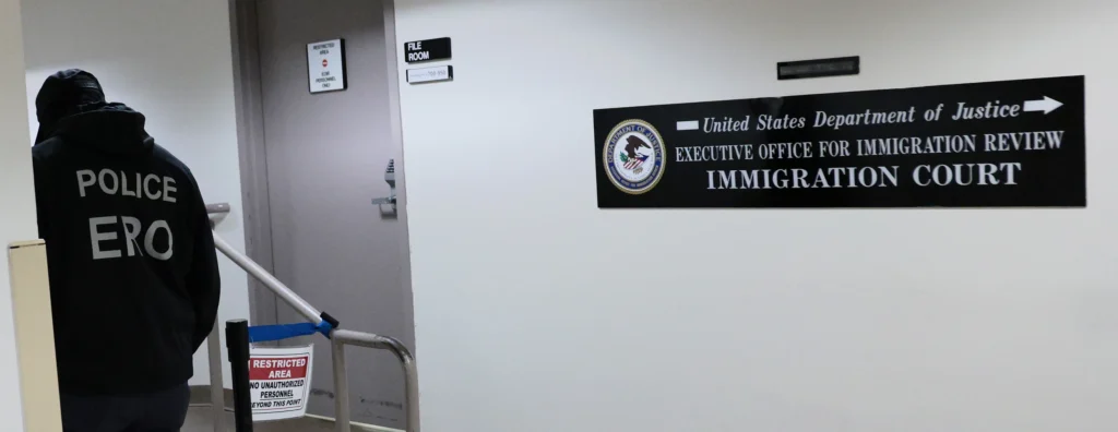 Masked federal agents patrol the halls of immigration court New York City in May 2026. Several fired immigration judges from courts across the country are challenging their dismissals.